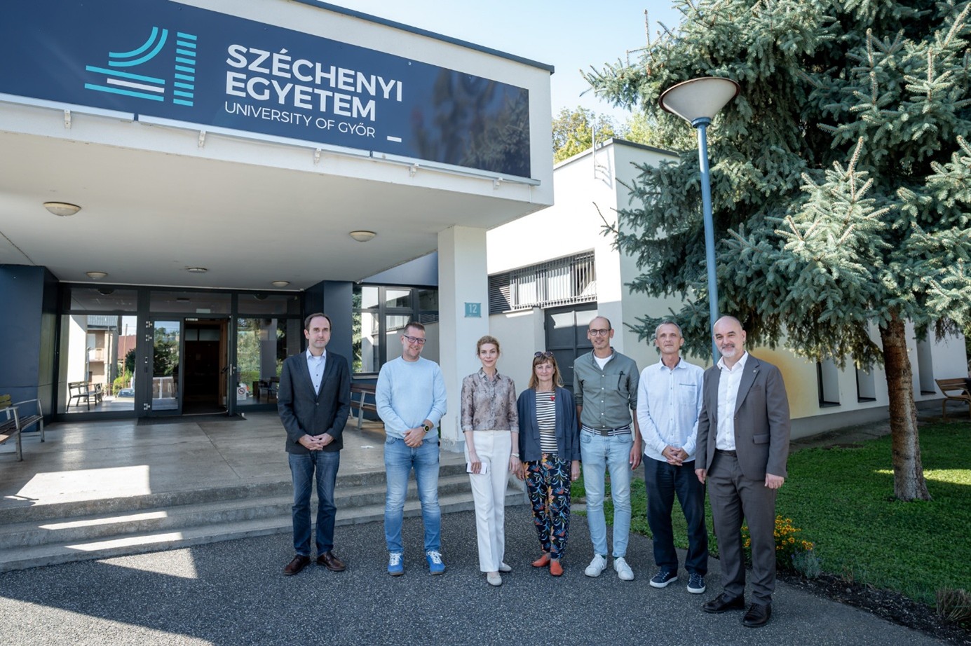 Dr László Knapp, Head of the Department of International and European Law at the Deák Ferenc Faculty of Law and Political Sciences, Zsolt Rotter, the University’s Director of Technical Development and Operations; Dr Nóra Géczy, a lecturer at the Faculty of Architecture, Civil Engineering and Transport Sciences; Kriszta Fülöp and Péter Szabó, lecturers at the Design Campus of the Faculty of Design and Performance Arts; Dr István Katona, Head of the Department of Architectural Design; and Professor Péter Smuk, Dean of the Faculty of Law, in front of the building on Áldozat utca. (Photo: András Adorján)